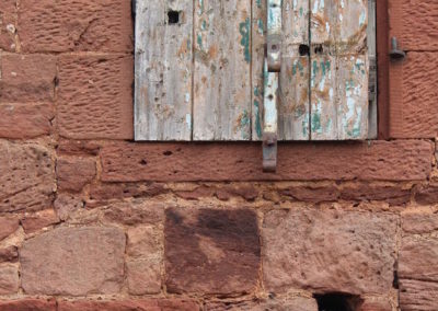 shutter door in a red block sandstone wall from the exterior of west barns arts
